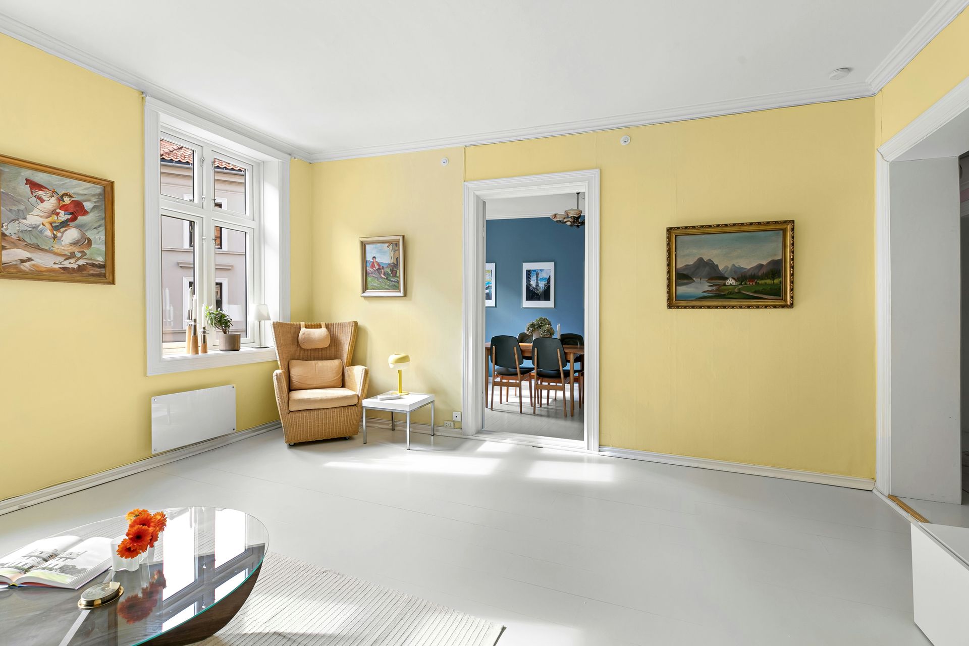 A living room with yellow walls and white floors